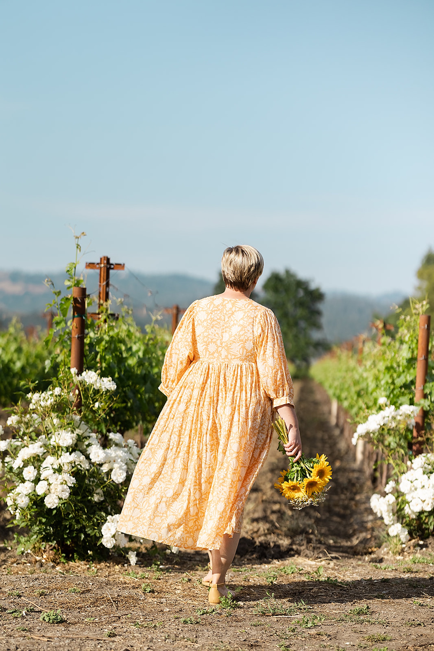 female walking down vineyard in Napa by Amy Thompson Photography