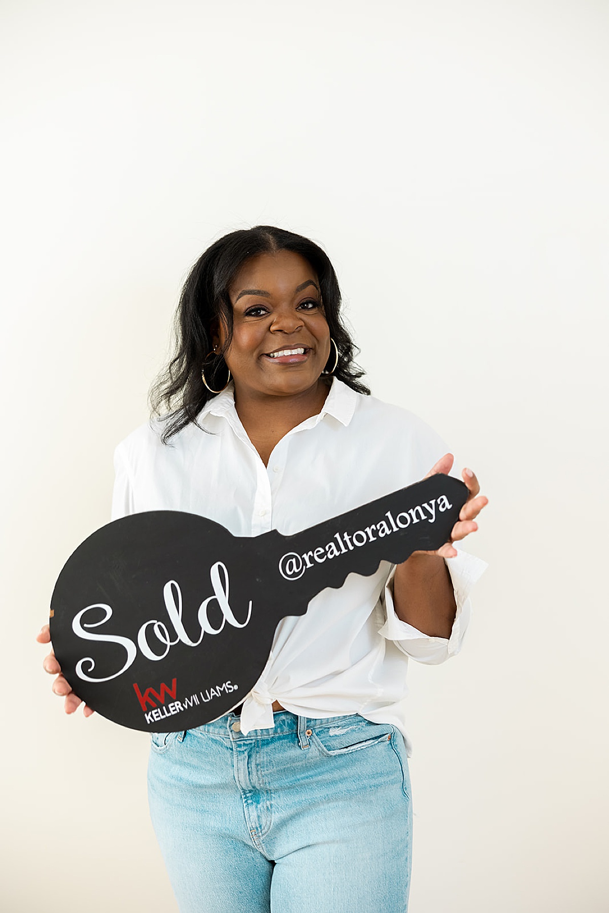 realtor holding sold sign in front of San Francisco photographer 
