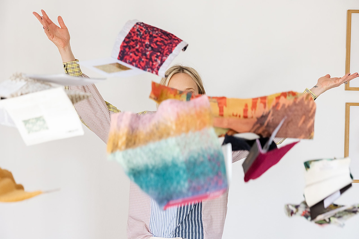 Women throwing her fabric samples in the air for a picture taken by Amy Thompson Photography
