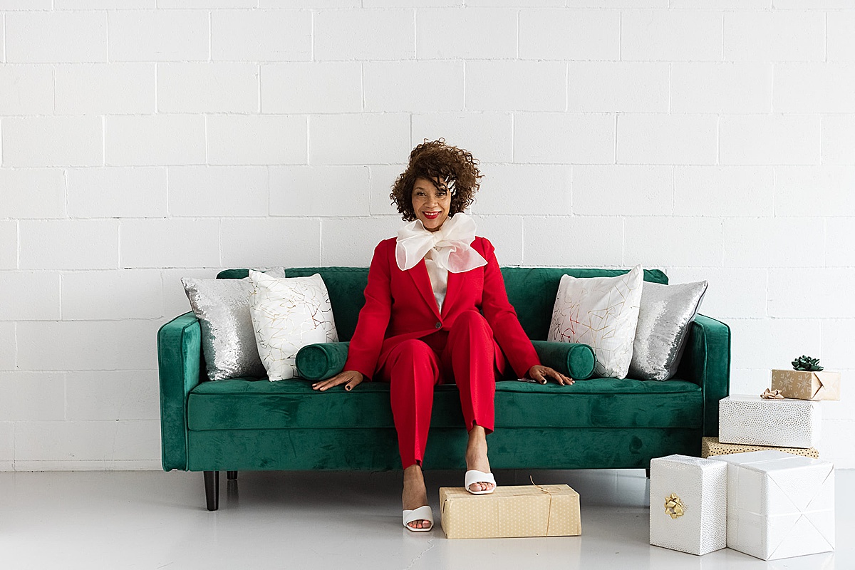women sitting on couch with foot on box during her indoor photo shoot