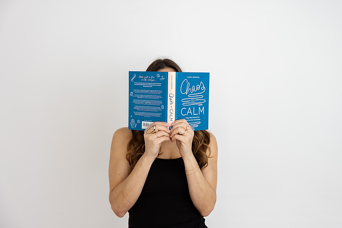 women covering her face with a book as a prop 