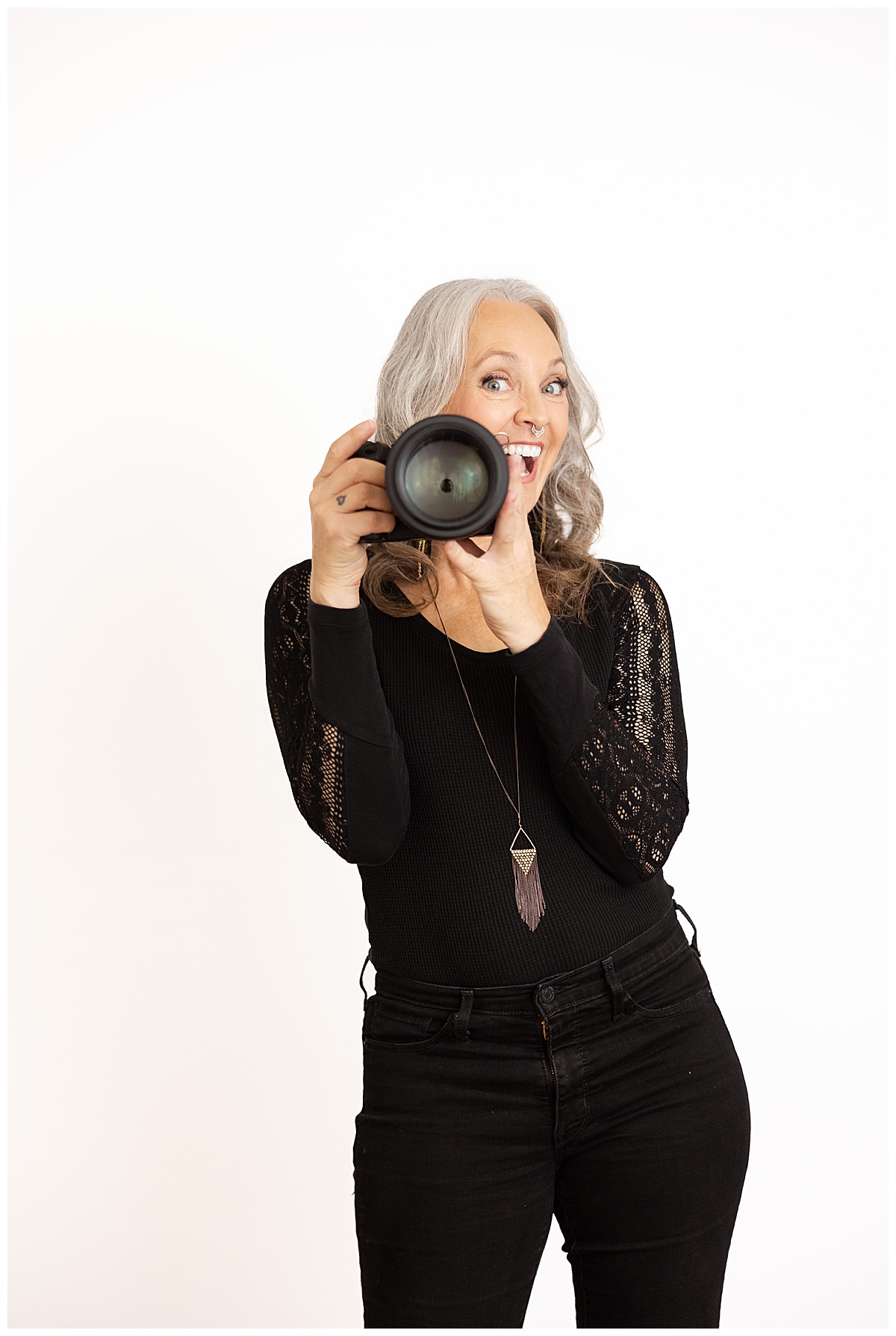 Client smiles behind her camera using Tips for your brand photoshoot