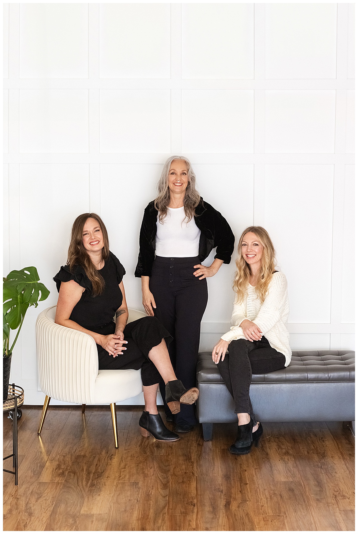 Three women sit and stand together near a couch for San Franciso brand photographer