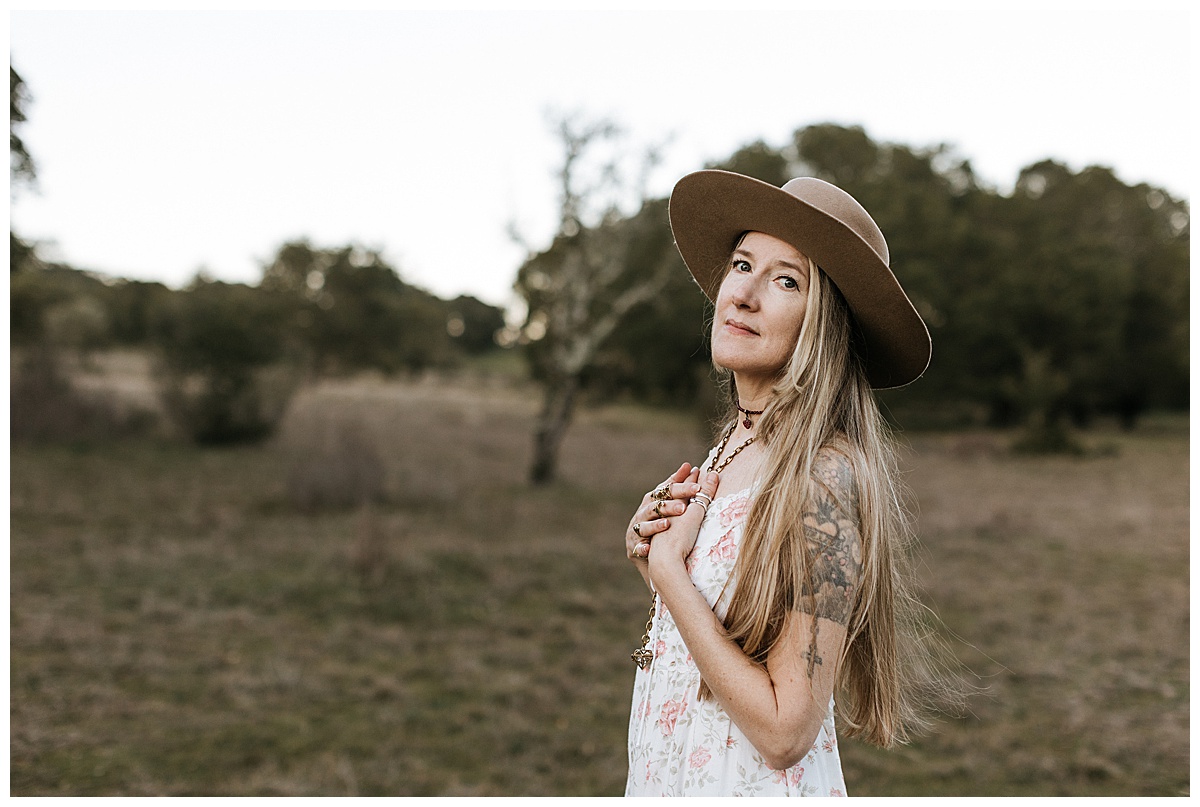 Woman holds her hands over her heart during her Healer Brand Photoshoot 